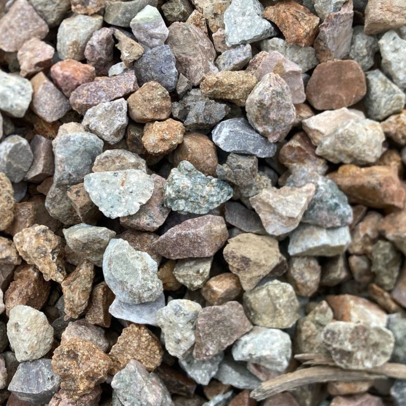 Close-up of mixed crushed stone gravel aggregate in brown and gray tones for landscaping, paths, and driveways.