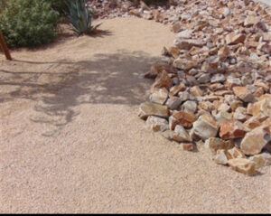 Xeriscape yard with decomposed granite path, agave, and pile of decorative rocks for desert landscaping