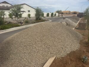 Large piles of gravel for landscaping along suburban street in new home construction neighborhood.