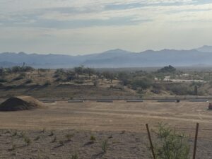 Sonoran Desert landscape with cacti, dusty foreground and hazy mountain ranges under a soft morning sky in Arizona